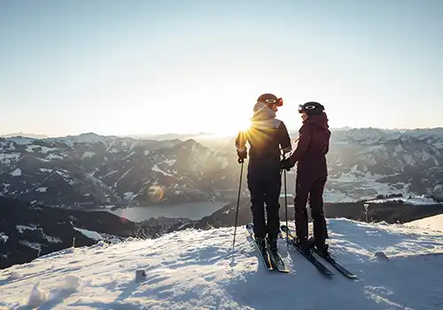 Wintermorgen in den Bergen mit zwei Skifahrern.