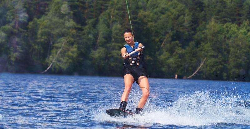 Junge Frau wakeboardet auf Zell am See